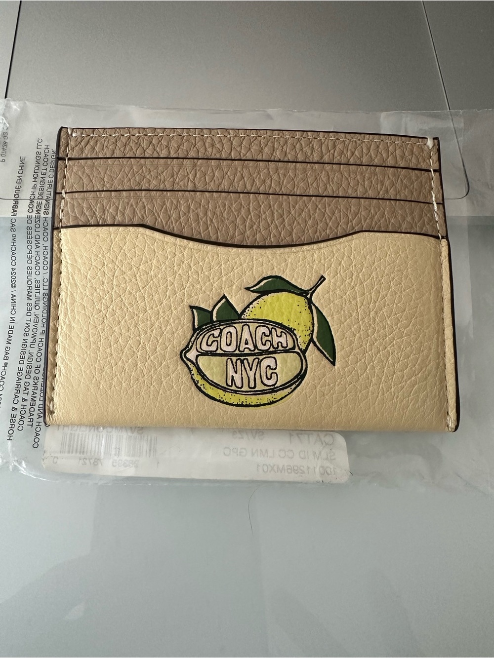Coach NYC tan and cream Lemon graphic card holder CAT71, NWT.